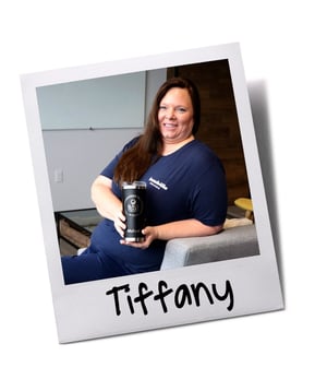 Employee holding Baudville personalized tumbler